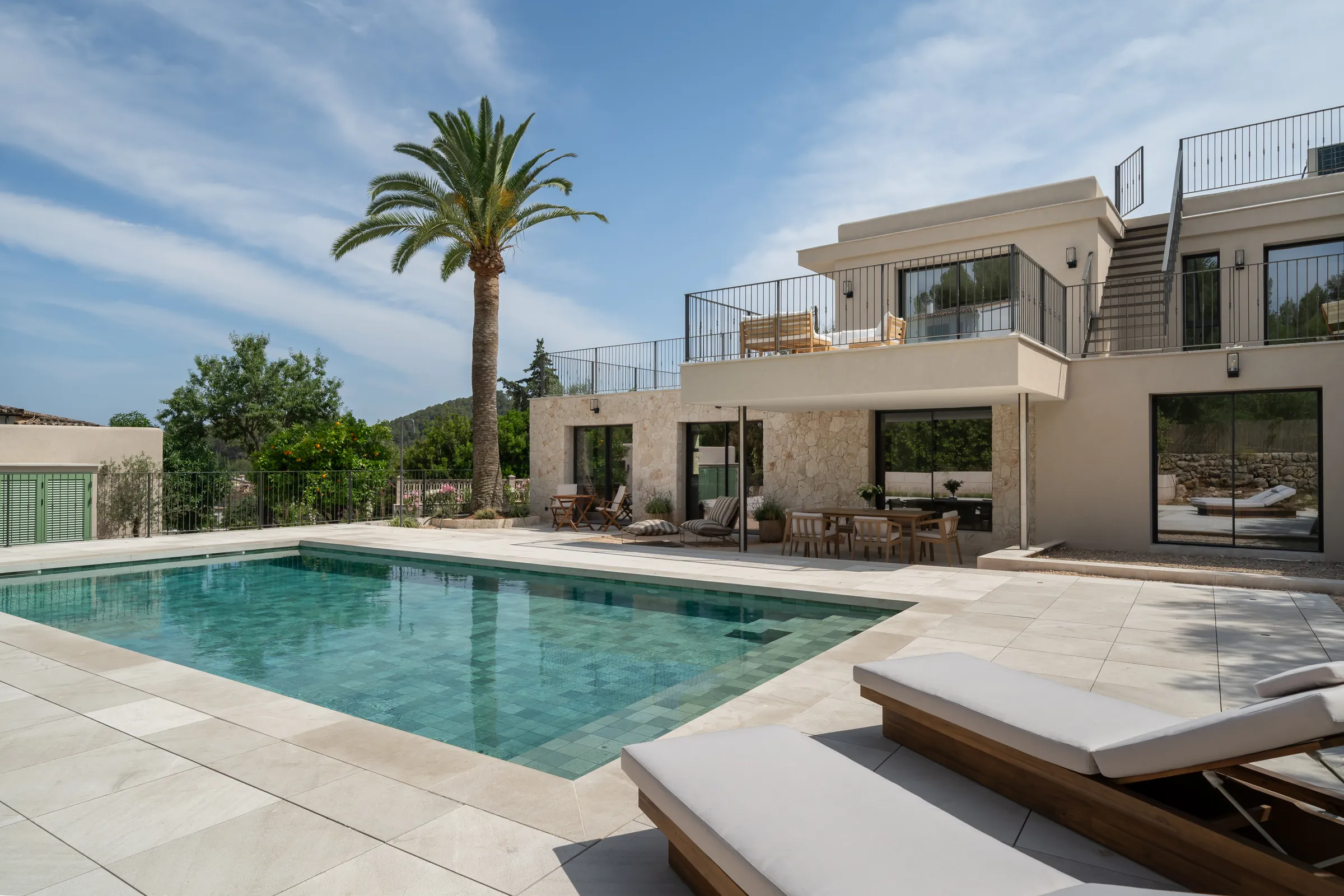 Piscina con tumbonas frente a la villa reformada en Es Capdellà (Calvià, Mallorca)